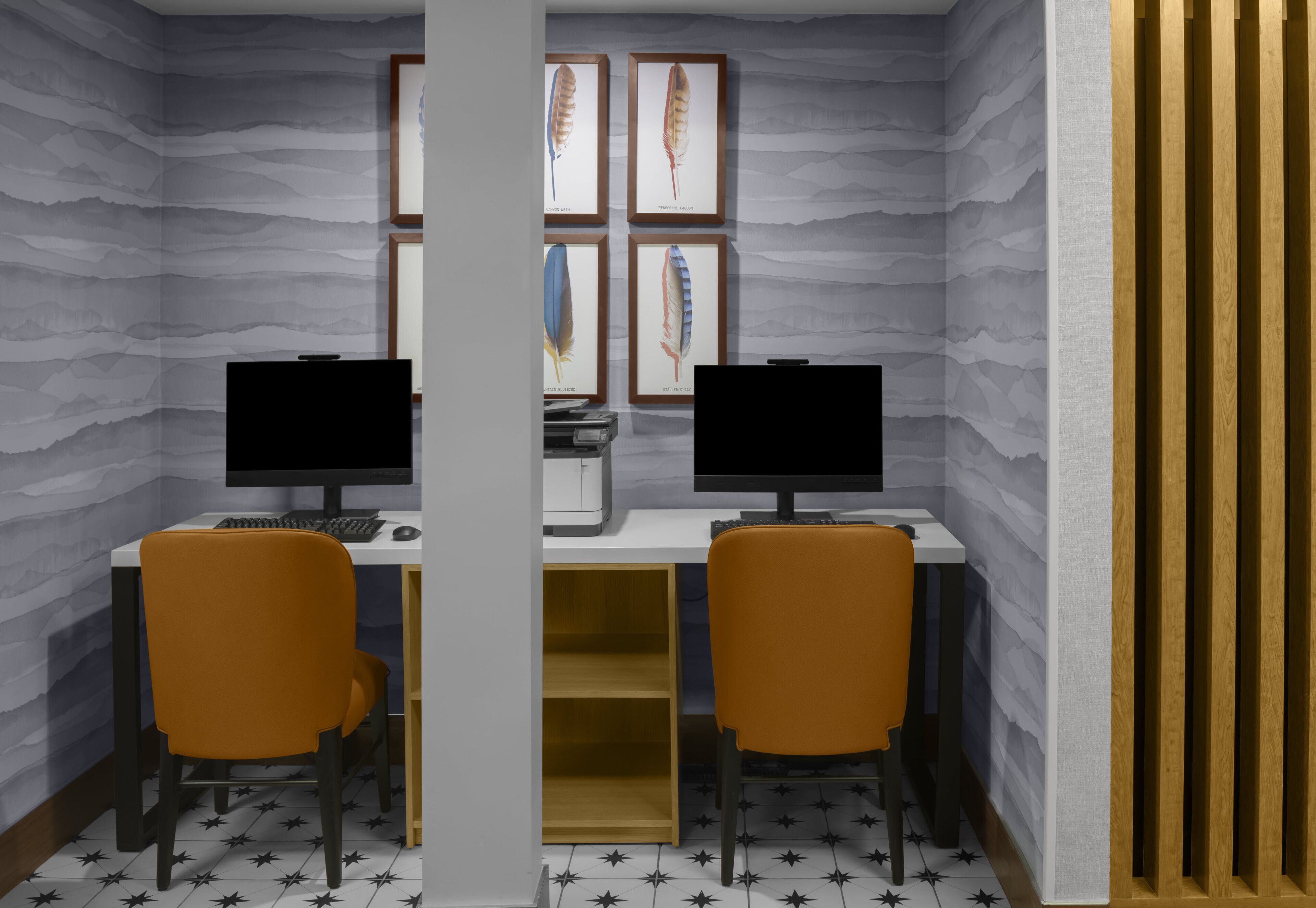 A room with two desks, two chairs, and a computer setup.