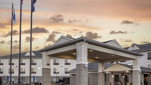 A hotel with a covered entrance, multiple flags, and a landscaped driveway. - Holiday Inn Express & Suites Montrose - Black Canyon Area by IHG (Montrose)