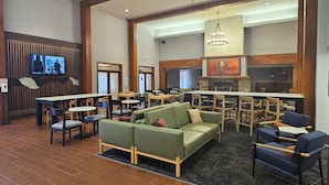 A spacious lobby with a seating area, a television mounted on the wall, and a fireplace. - Holiday Inn Express & Suites Montrose - Black Canyon Area by IHG (Montrose)