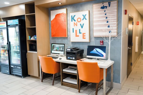 A hotel lobby with a reception desk, two computers, a refrigerator, and a fire extinguisher. - Holiday Inn Express & Suites Knoxville-North-I-75 Exit 112 by IHG (Powell)