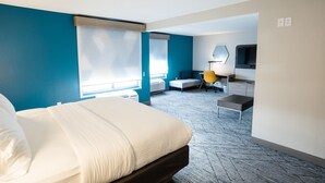Una habitación de hotel con una cama, un escritorio, una silla, un televisor y una ventana.