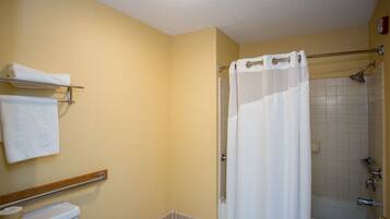 Une salle de bain avec douche, toilettes et porte-serviettes.