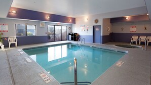 An indoor swimming pool with clear water, a lifeguard chair, and a sunburst decoration on the wall. - Vagabond Inn Executive - Green Valley (Green Valley)