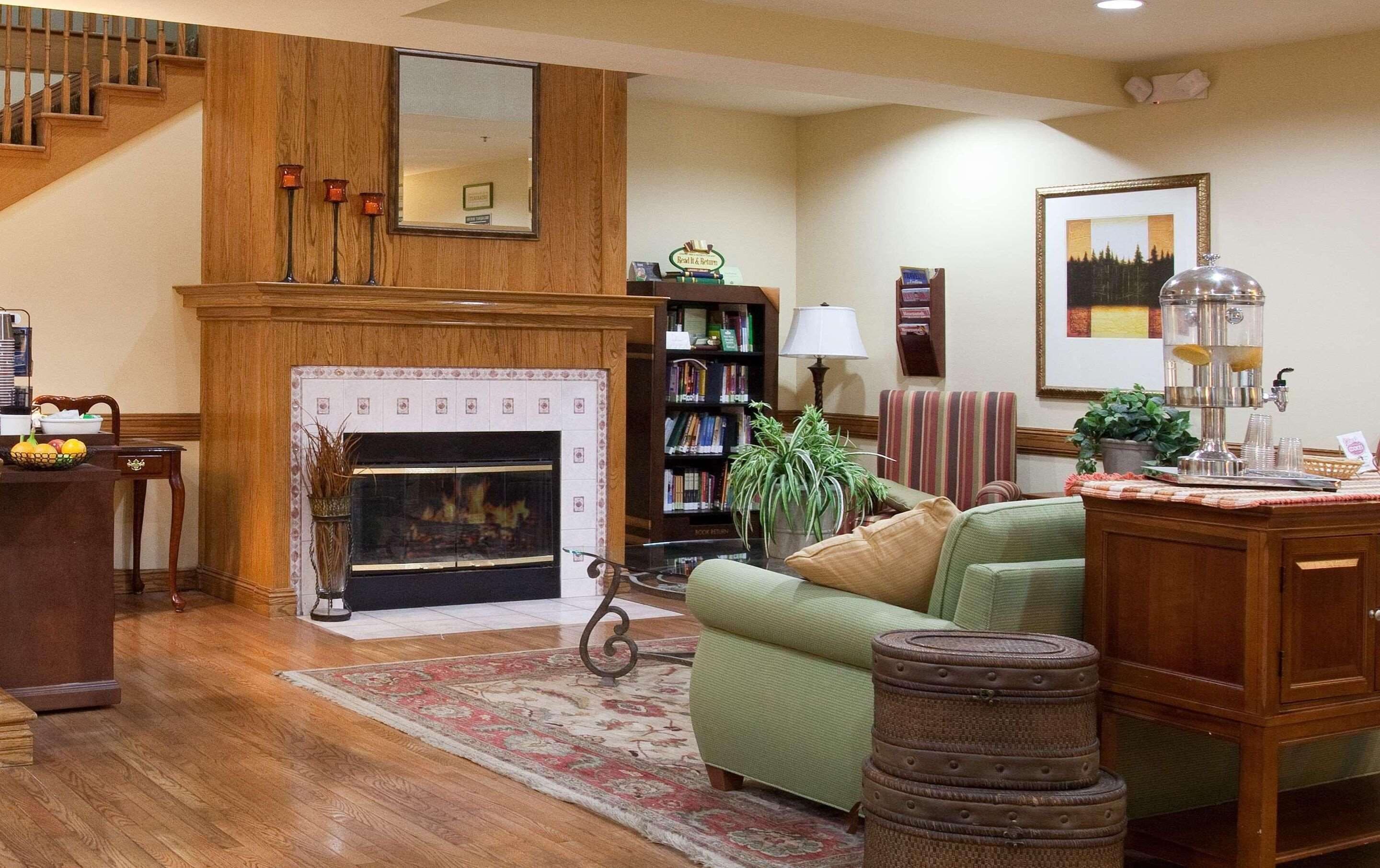 A cozy living room with a fireplace, a bookshelf, a green sofa, and a coffee table.