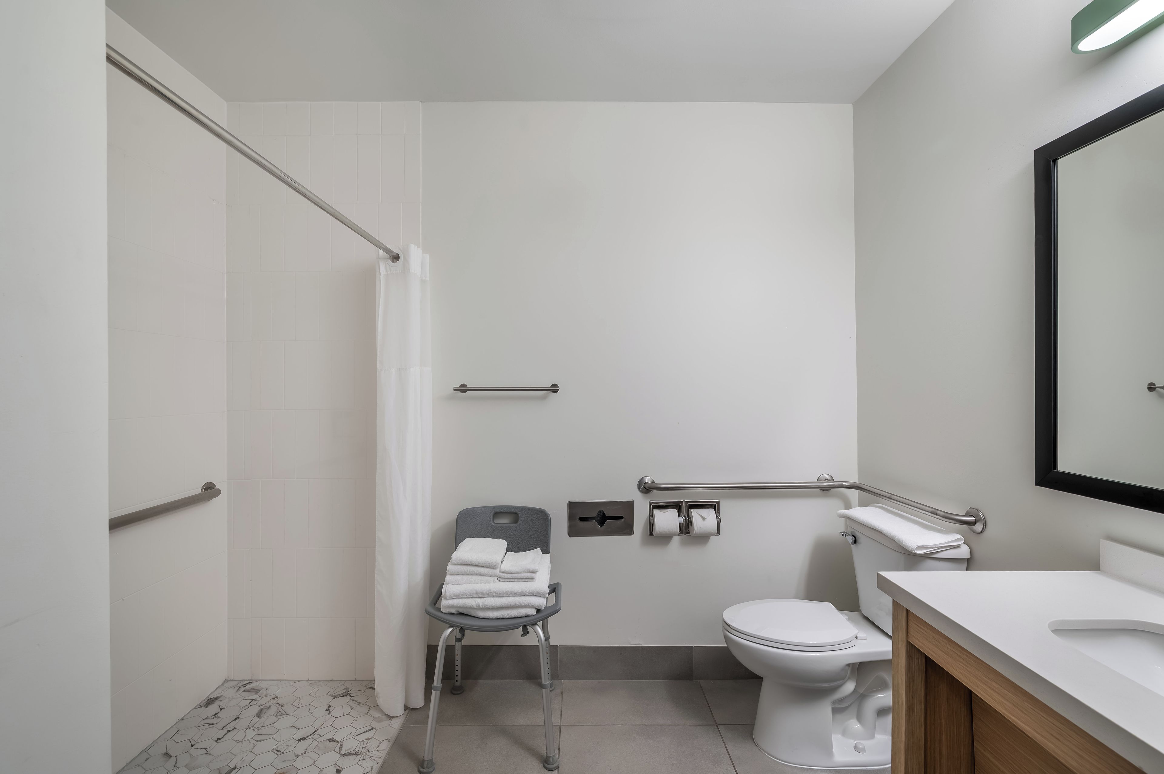 A modern bathroom with a shower, toilet, and sink.