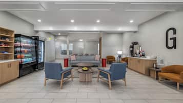 A modern lounge area with seating, a refreshment machine, and a visible 'Garner Shop' sign.