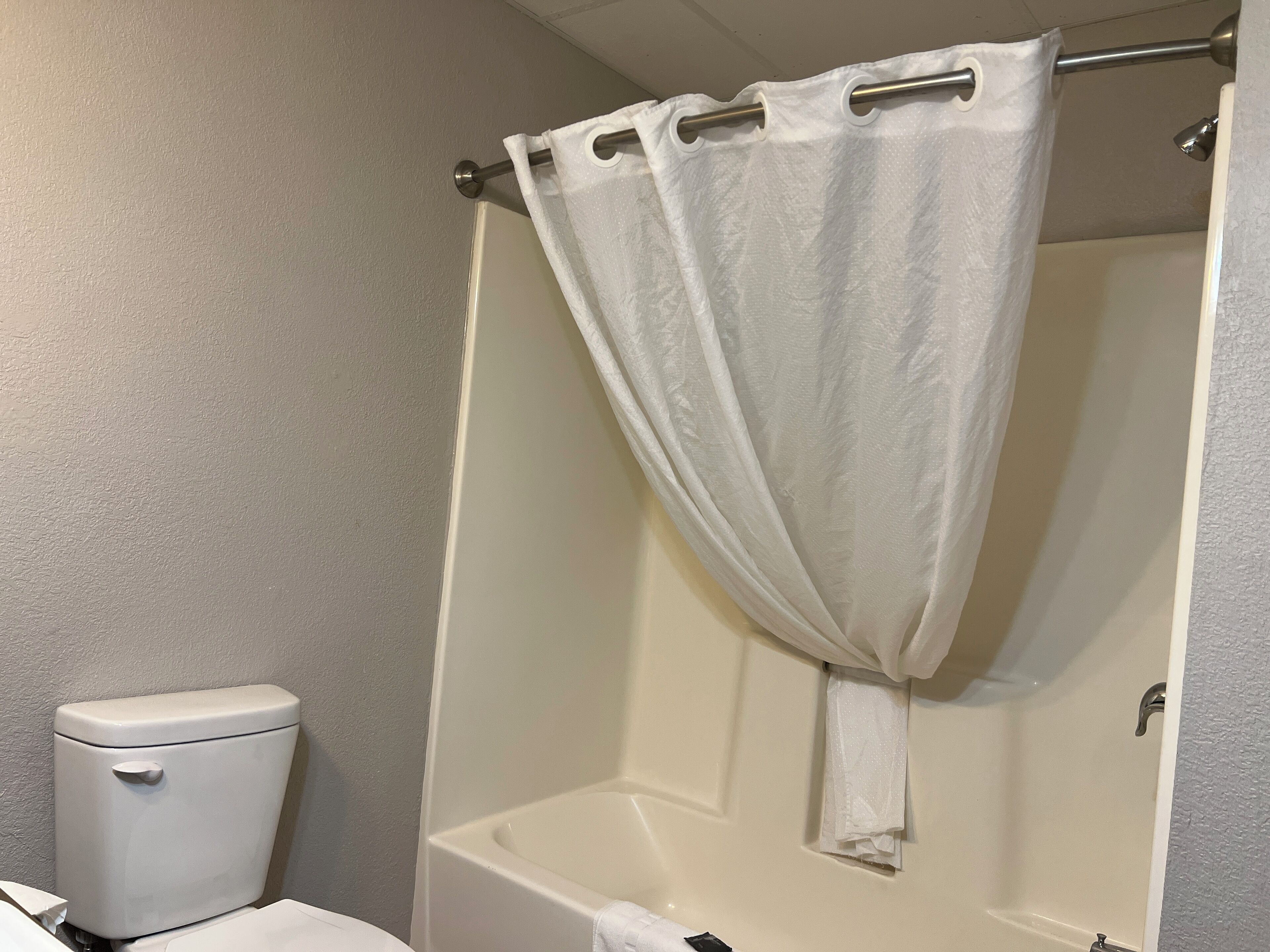 Un baño con inodoro, bañera y cortina de ducha.