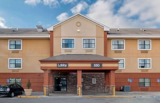 A hotel lobby with a beige facade, multiple windows, and a sign indicating the lobby and room number 550.