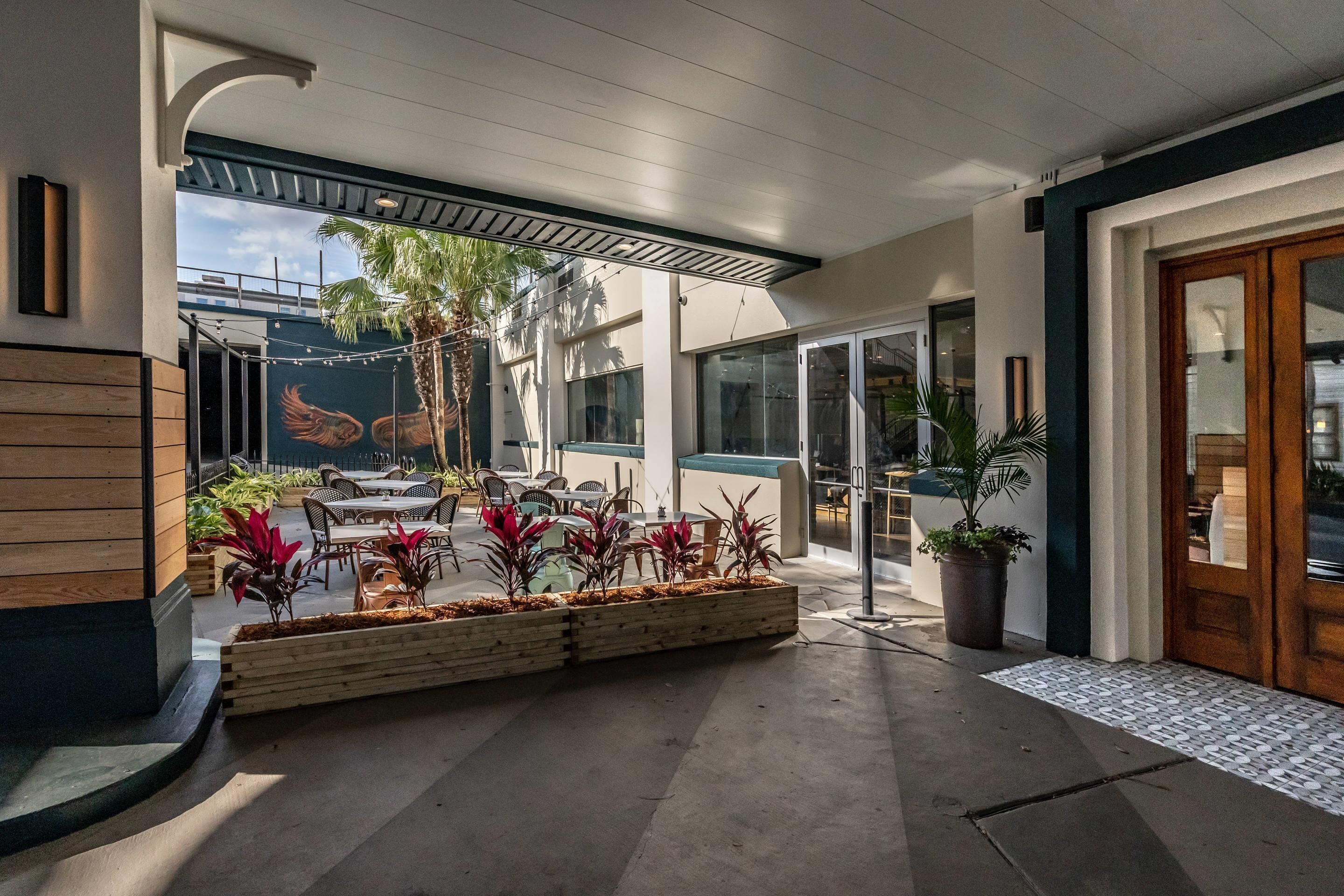 Un espacio de patio al aire libre con jardineras de madera, asientos y vistas a la ciudad.
