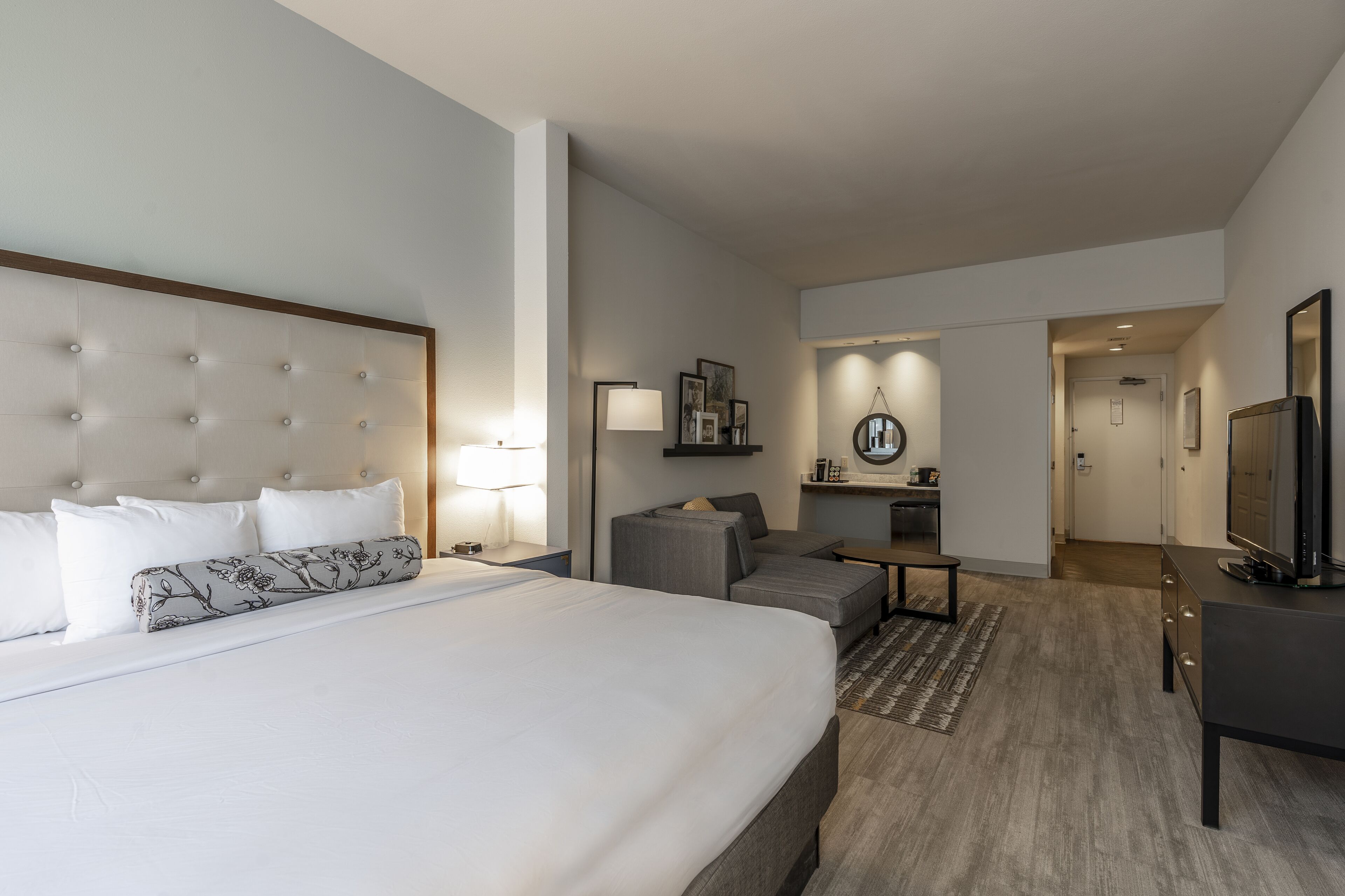 Une chambre d’hôtel avec un grand lit, un canapé, un bureau et une télévision.