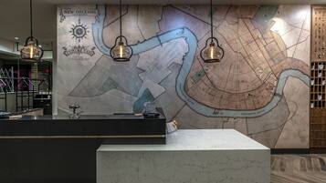 A reception desk with a large map of New Orleans, Louisiana, and a wooden panel with a grid pattern.