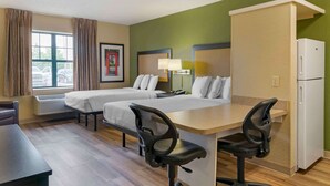 A hotel room with two beds, a desk, two office chairs, a refrigerator, a lamp, and a window with curtains. - Extended Stay America Suites Detroit Madison Heights (Madison Heights)