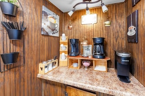 Una cocina con paneles de madera, una cafetera y diversos objetos relacionados con el café.