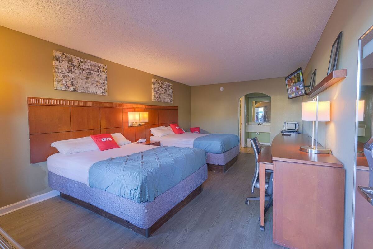 Una habitación de hotel con dos camas, un escritorio y una silla.