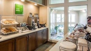 A breakfast bar with various food items, a coffee machine, and a sign that says "YOUR morning goodness". - Comfort Inn & Suites Spokane Valley Central (Spokane Valley)