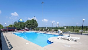 Área de piscina com espreguiçadeiras e placa da Days Inn.
