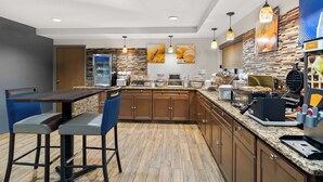 A modern kitchen with a central island, bar stools, and a variety of appliances. - Comfort Inn Joliet West I-80 (Joliet)