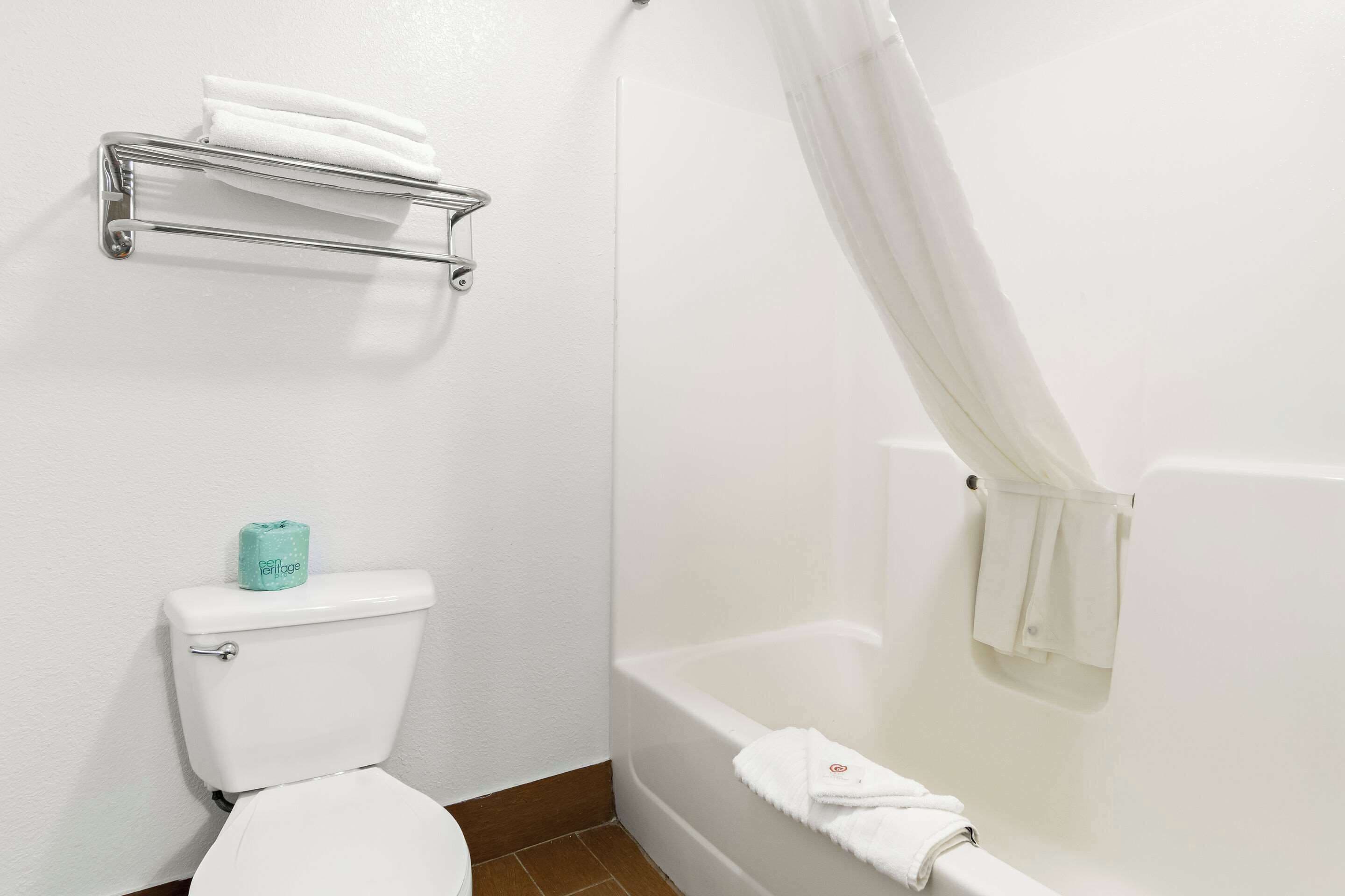 Un baño con inodoro, bañera y toallero.