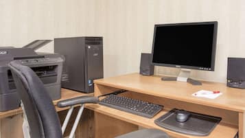 Een bureau met een computer, toetsenbord, muis en speakers.
