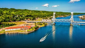 A bridge over a river with a boat creating a wake. - Ramada by Wyndham Hancock Waterfront (Hancock)
