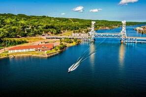 A bridge over a river with a boat creating a wake. - Ramada by Wyndham Hancock Waterfront (Hancock)