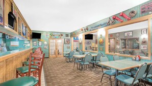 Un restaurante de estilo retro con barra de madera y cabinas, recuerdos antiguos en las paredes y suelo a cuadros.