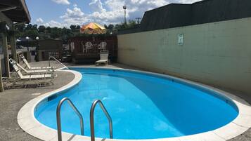 Una piscina al aire libre, sillones reclinables de piscina