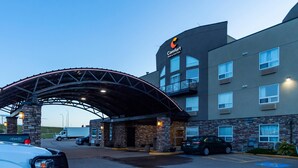 Un hôtel Comfort Inn & Suites doté d’une entrée abritée, d’une façade en pierre et de nombreuses fenêtres.