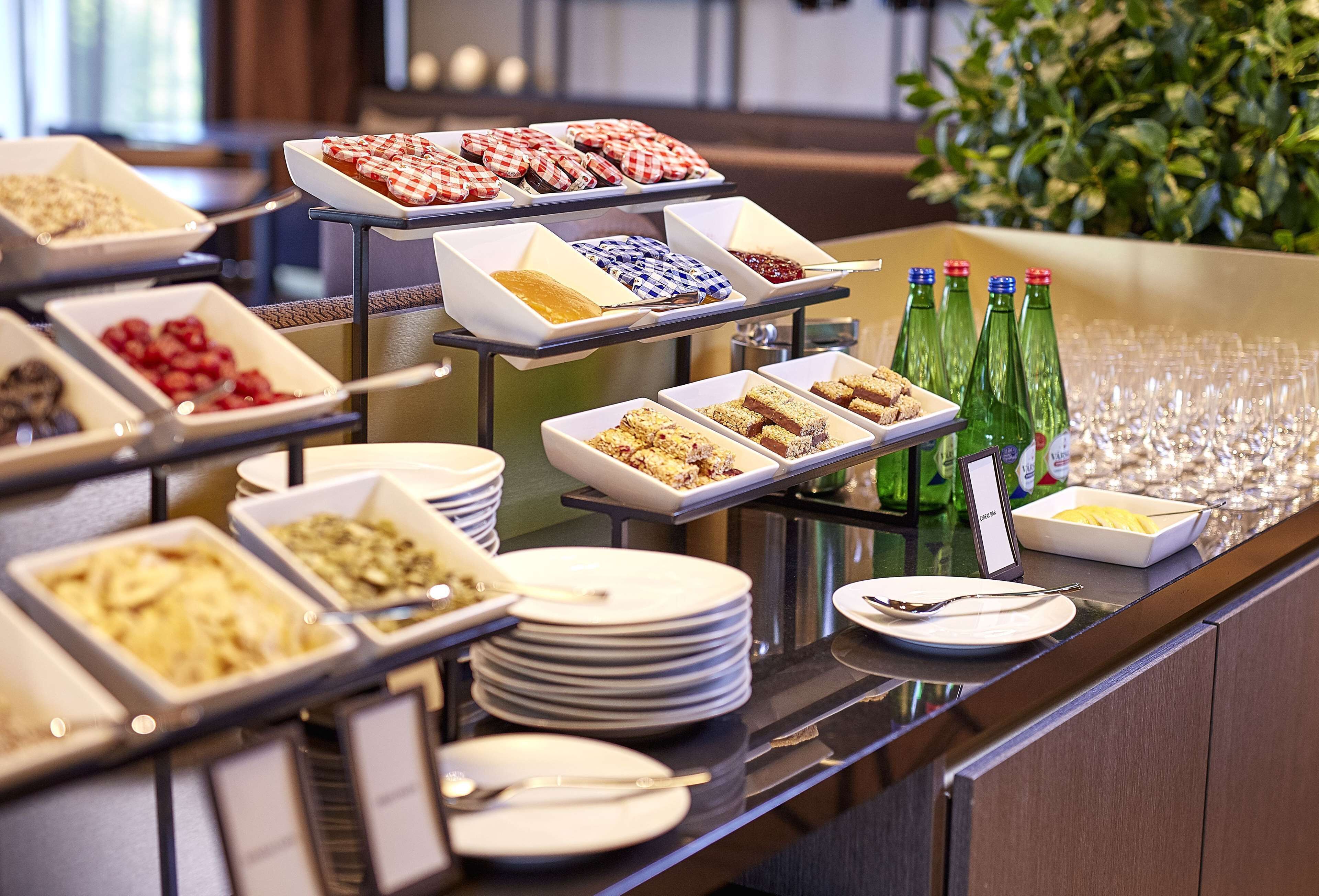 Buffet com diversos alimentos e garrafas de refrigerante verde.