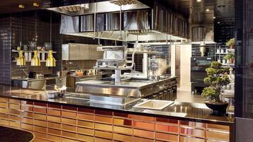 Una cocina moderna con electrodomésticos de acero inoxidable, una isla grande y lámparas colgantes.
