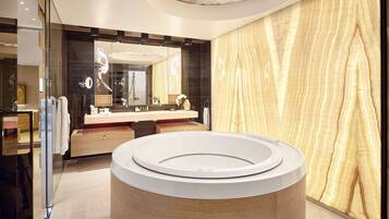 Ein modernes Badezimmer mit einer großen, runden Badewanne, einem Doppelwaschbecken mit Spiegel und einer Wand mit Holzstruktur.