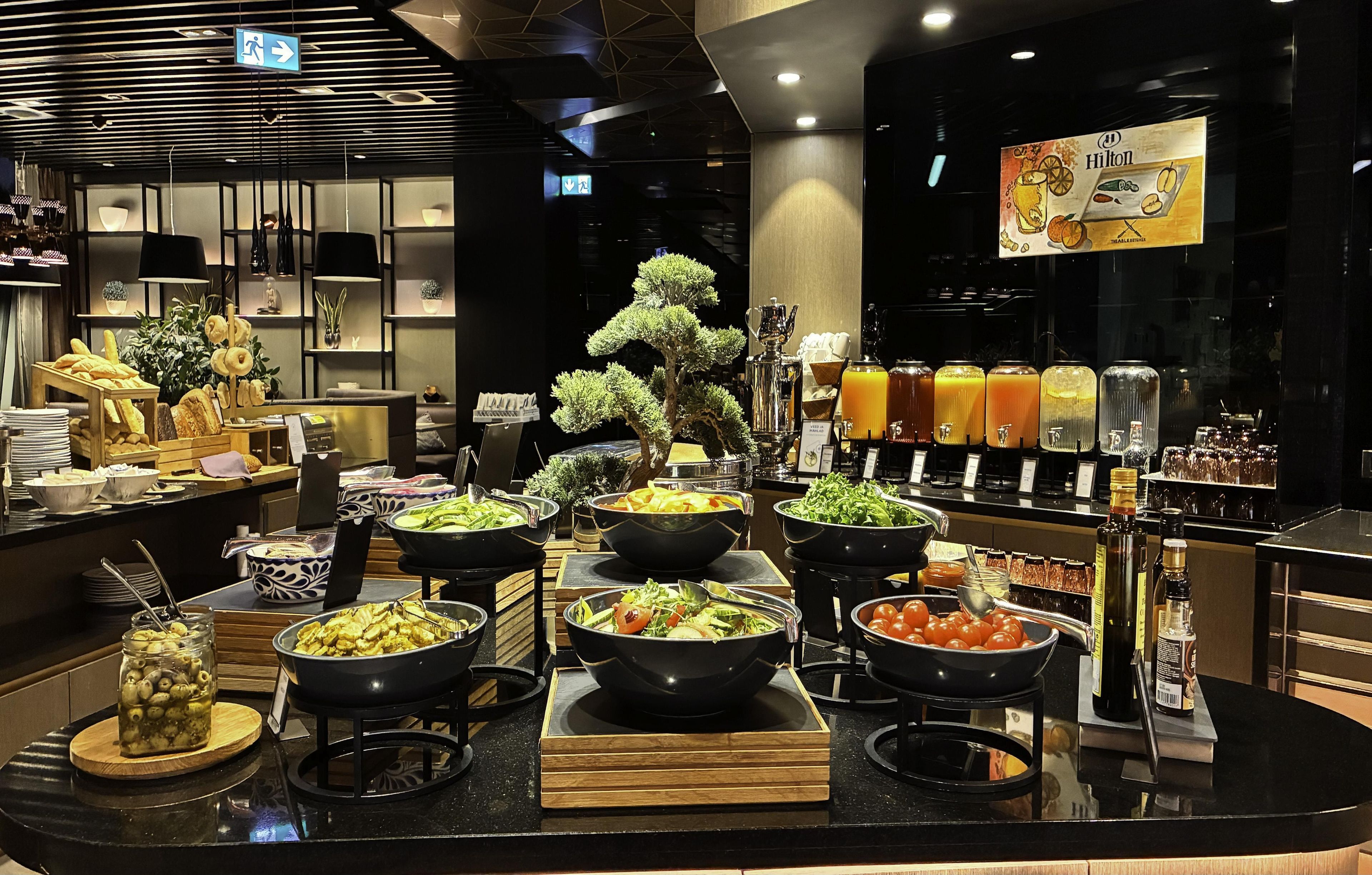 A buffet area with various food options, including salads, fruits, and beverages.