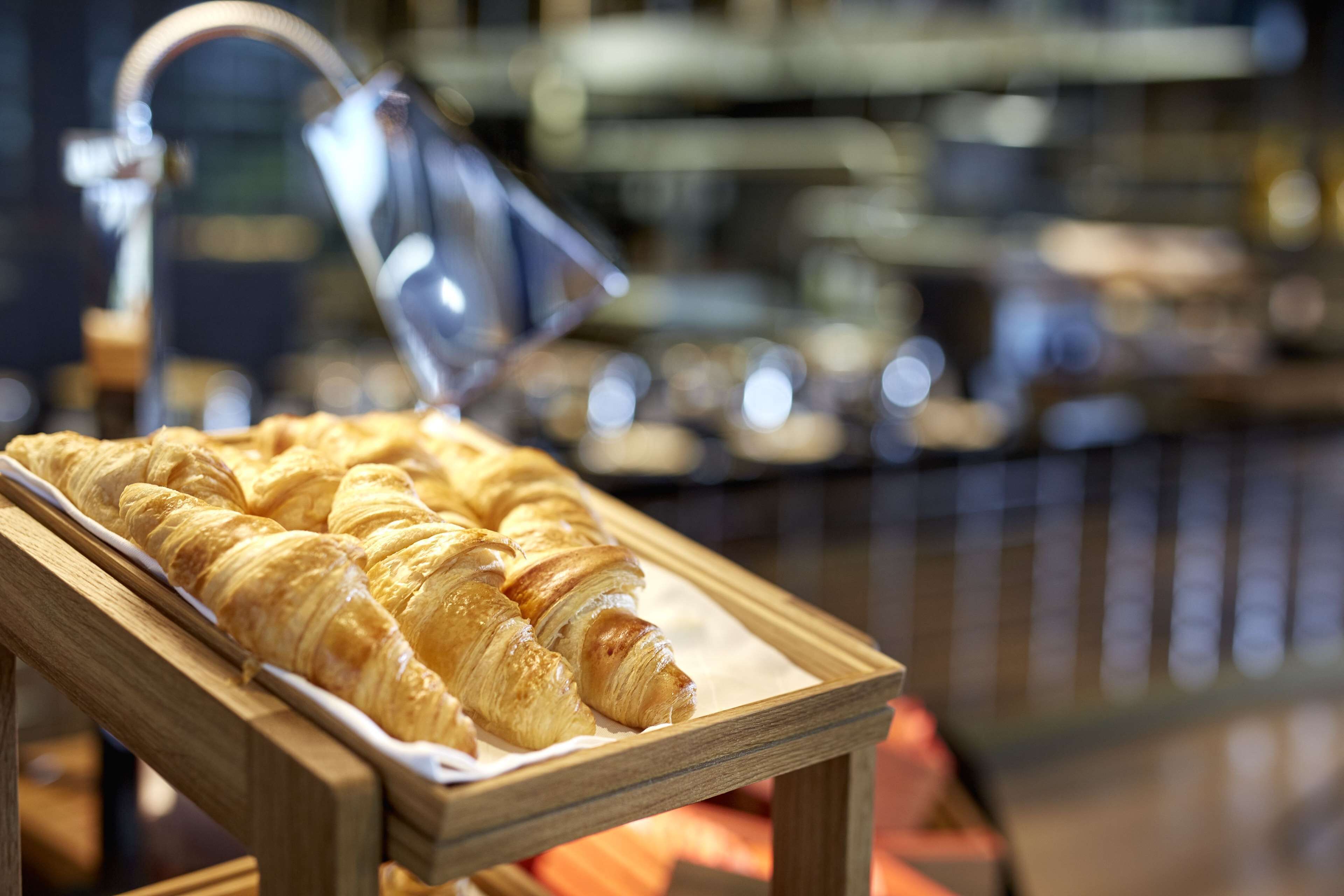 A wooden serving tray with croissants.