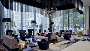 A modern lobby with a seating area, large windows, and a chandelier. - Hilton Tallinn Park (Tallinn)