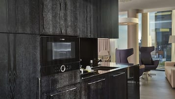 Een moderne keuken met een Bosch magnetron, donker houten keukenkastjes en een strak keukenblok met een spoelbak.