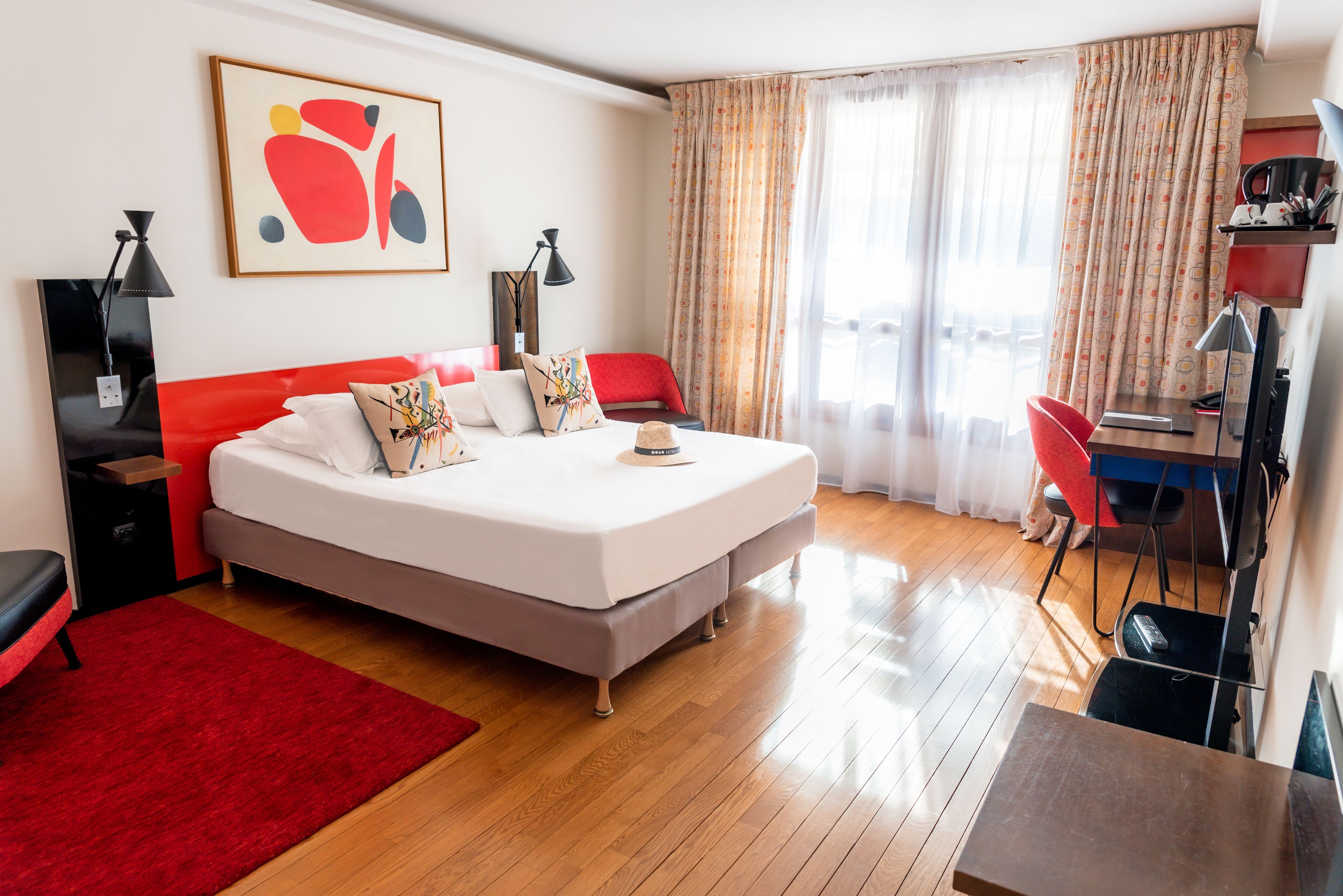 Quarto de hotel moderno com uma cama grande, uma escrivaninha e uma cadeira.