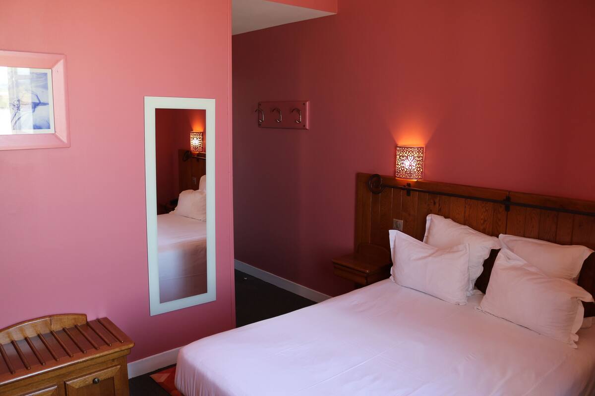 Ein Hotelzimmer mit Bett, Nachttisch und Spiegel.