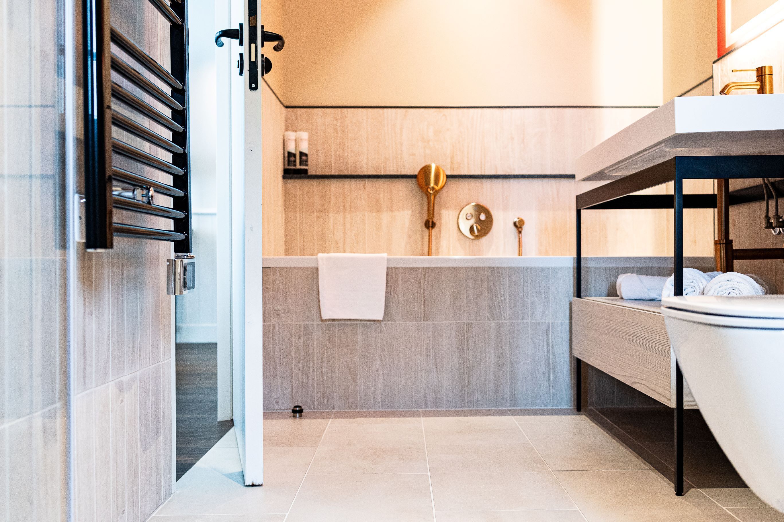 Un baño moderno con bañera, lavamanos y tocador.
