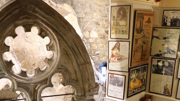 A restaurant interior with stone walls, framed pictures, and tables set for dining.