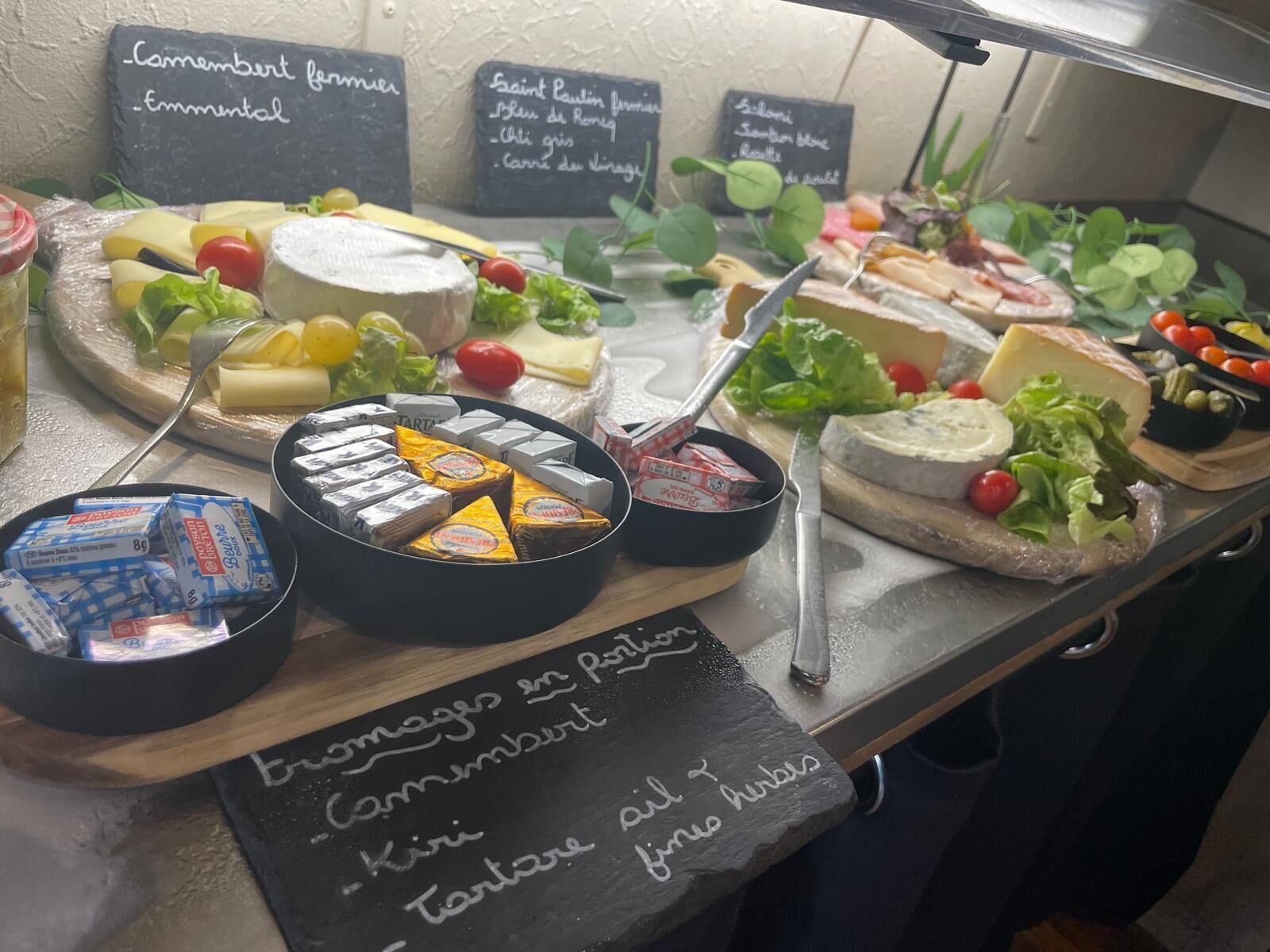 Een kaas- en vleeswarenplank met verschillende kazen, fruit en noten.