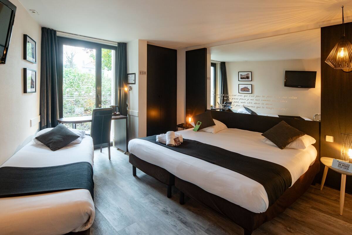 Een hotelkamer met twee bedden, een televisie, een bureau en een balkon met gordijnen.