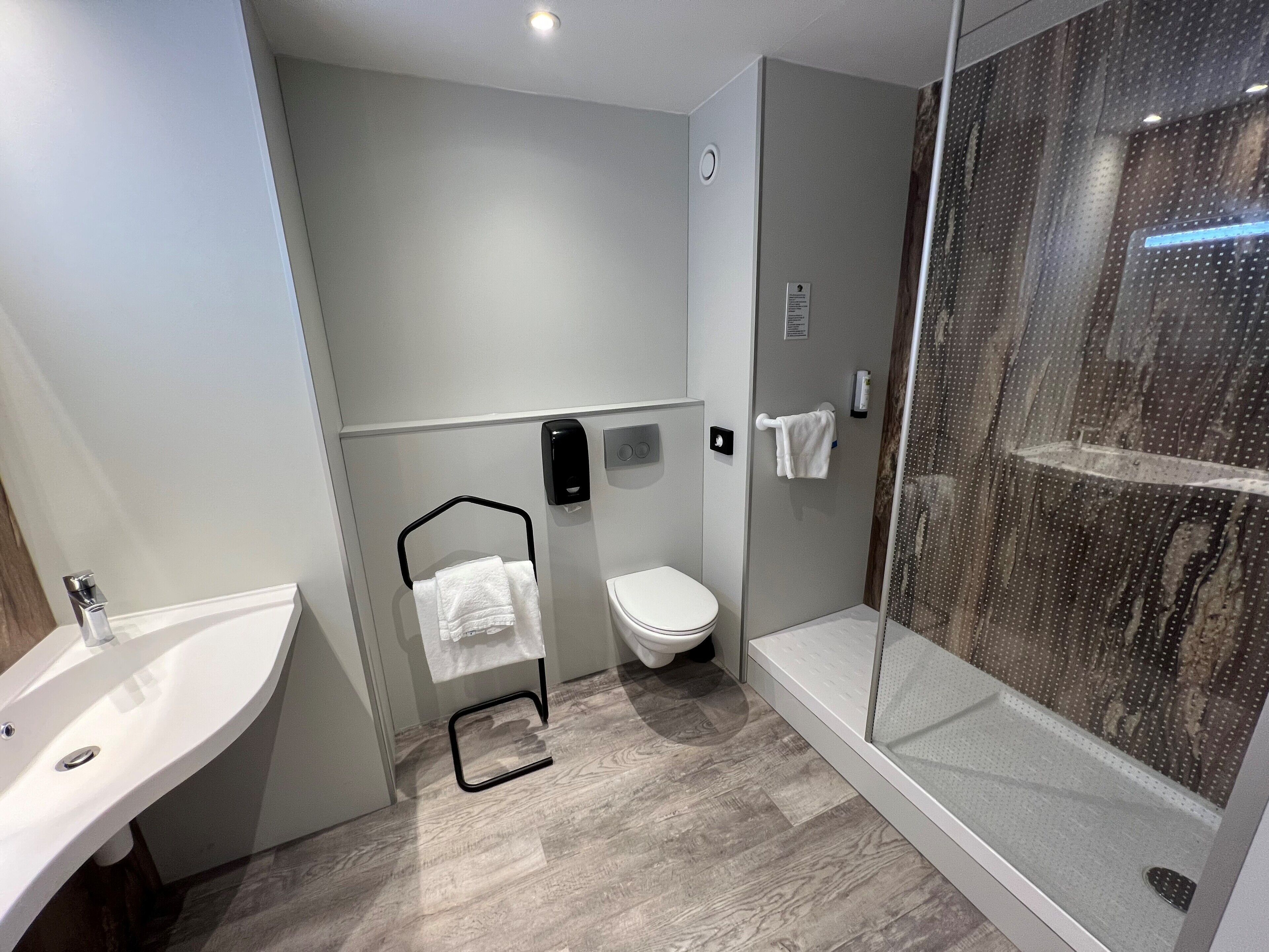 Un baño moderno con ducha, inodoro y lavamanos.