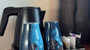 Un coin café avec deux tasses bleues et une cafetière noire, le tout disposé sur un plateau.