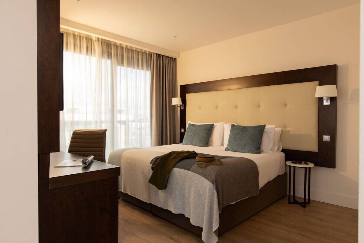 Una camera d'albergo con un letto grande, una scrivania e una sedia.