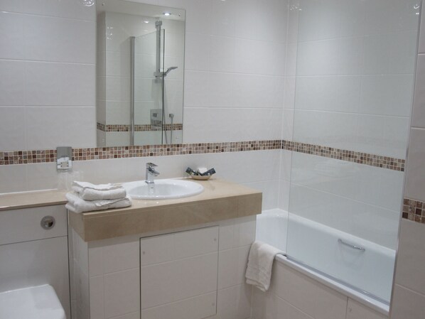 Une salle de bain moderne avec un lavabo, un miroir et une douche.
