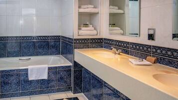 A bathroom with a bathtub, two sinks, and a mirror.
