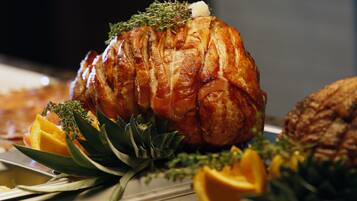 A roasted turkey garnished with herbs and orange slices on a serving platter.
