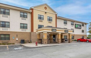 Un hotel con entrada al vestíbulo, un hidrante y un estacionamiento con coches.