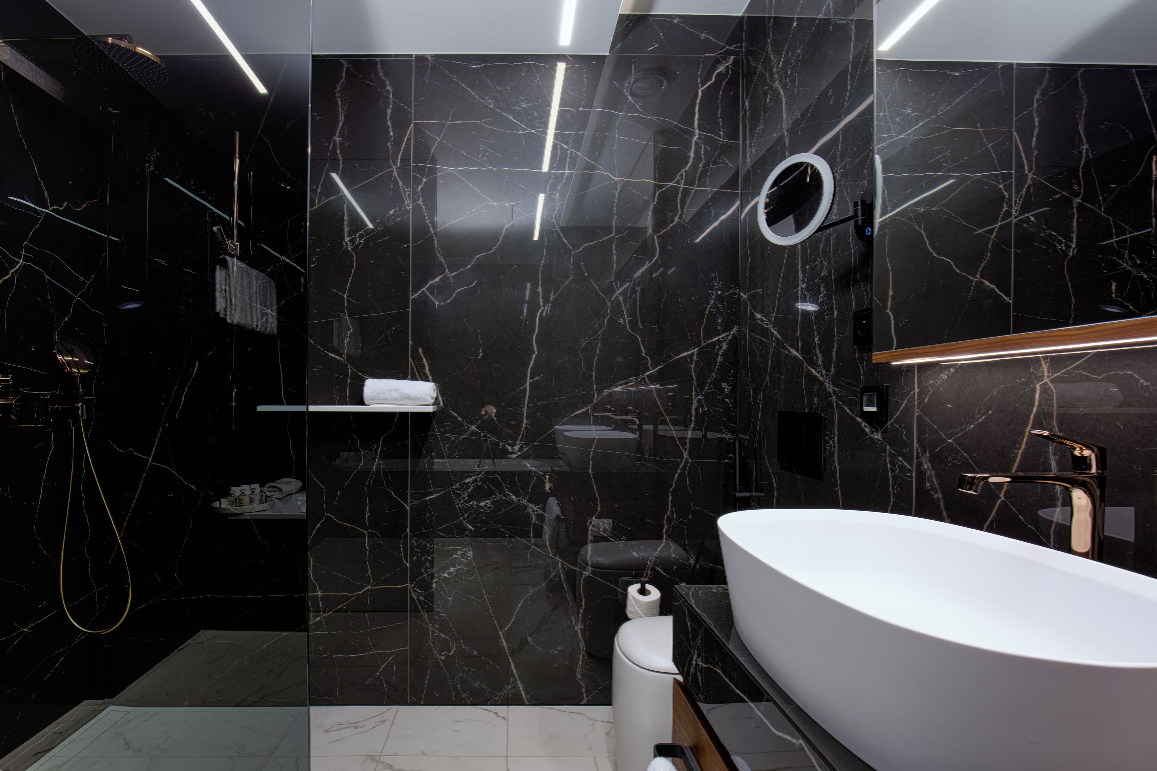 Ein modernes Badezimmer mit einer freistehenden Badewanne, einem Waschtisch inklusive Spiegel und einer Toilette.