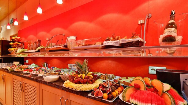 Un buffet proposant une variété de fruits, de légumes et de desserts.